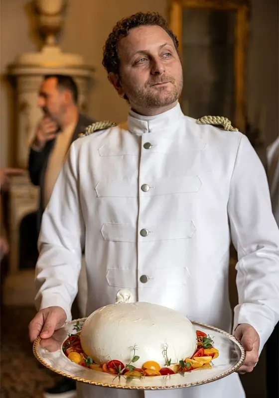 Camisa Essential, un serveur présente une grande burrata sur un plateau en argent ouvragé