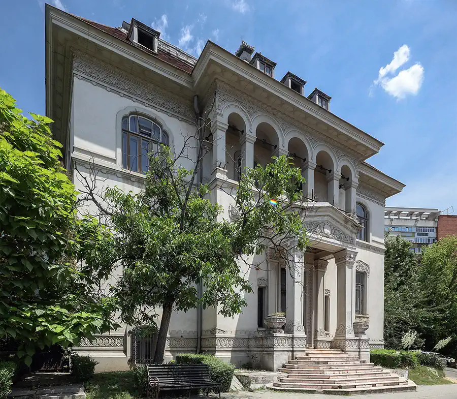 Façade de Casa Băileșteanu à Craiova avec loggia en plein cintre, frises de stuc ornementales et grand escalier d’entrée